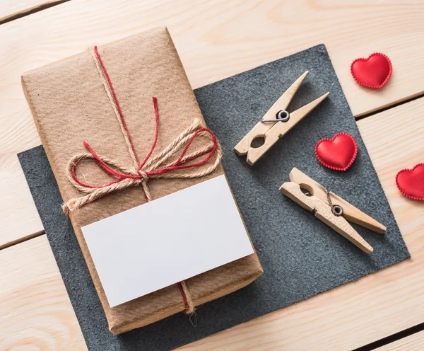 Caja de regalo con etiqueta blanca en blanco y corazones . — Foto de Stock