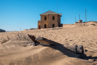 Arka planda eski maden kasabası Kolmanskop ile eski bir demiryolu rayları