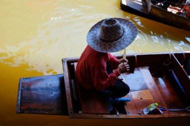 Ratchaburi 'deki Damnoen Saduak yüzer pazarında bir turist teknesinin kürekçisi. bangkok