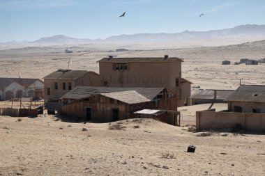 Kolmanskop hayalet kasabası, eski maden kasabası, terk edilmiş evler çöl kumları altında gömülü.