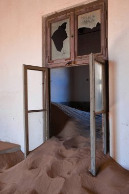 Kolmanskop 'ta bir evin içinde, penceresi çöl kumuyla kaplanmış. Kolmanskop, namibya