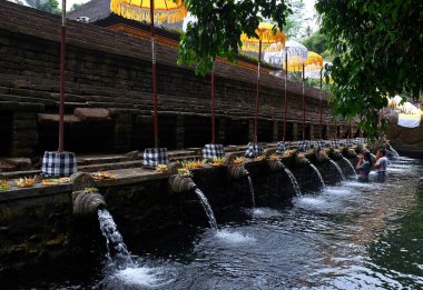 Tanınmayan Balili çift Pura Tirta Empul tapınağının kutsal kaynak suyunda dua edip arınma ayini yapıyorlar. Bali