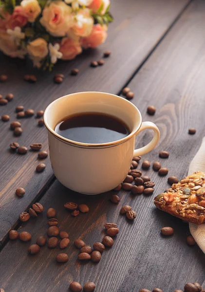 Café du matin dans une tasse blanche sur une table brune avec des fleurs et de la cannelle Photo De Stock