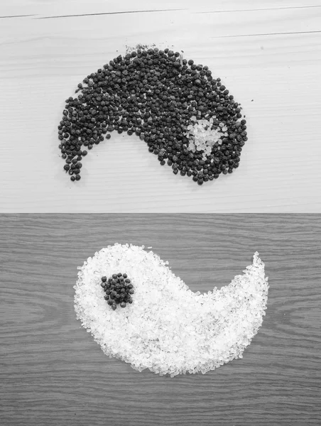 Salt and pepper on wooden background as yin and yang black and white — Stock Photo, Image