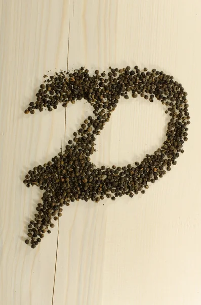 Pepper as "P" letter on wooden background — Stock Photo, Image