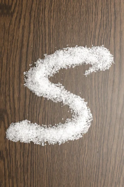 Salt som "S" senare på trä bakgrund — Stockfoto