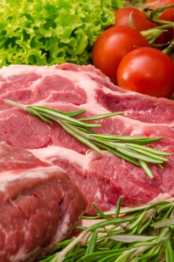 Sebzeli çiğ et ve ahşap arka planda baharatlar.