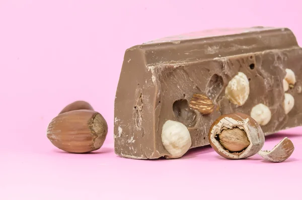 Milk chocolate with huzelnuts isolated on pink — Stock Photo, Image