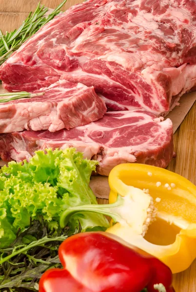 Carne cruda con verduras y especias sobre fondo de madera — Foto de Stock