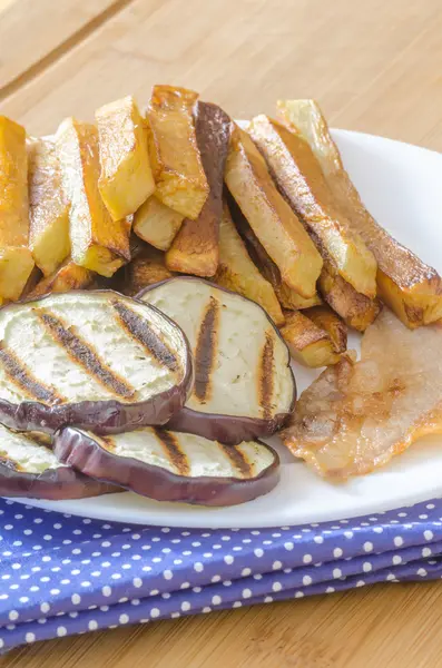 Papas fritas con berenjena a la parrilla sobre fondo de madera —  Fotos de Stock