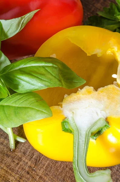 Bulgarian peppers with basil on wooden table — Stock Photo, Image