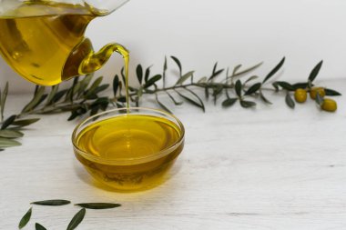 Arka planda zeytin dalı ve zeytin dalıyla süslenmiş ekstra saf zeytinyağı şişesi var. Akdeniz diyet kavramı