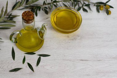 Arka planda zeytin dalı ve zeytin dalıyla süslenmiş ekstra saf zeytinyağı şişesi var. Akdeniz diyet kavramı