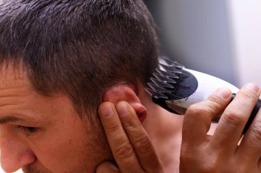 Adam evde kendi saçını kesiyor. Yakın plan portre