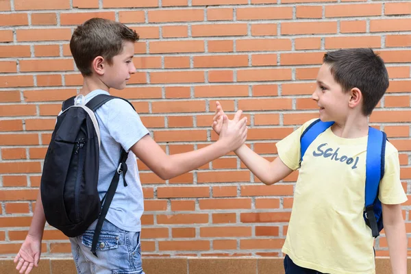 Két Iskolás Gyerek Hátizsákkal Üdvözöli Egymást Fogantatás Vissza Iskolába — Stock Fotó