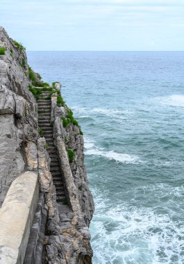 Denize bakan bir kayanın üzerinde çıkışı olmayan antik taş merdiven.