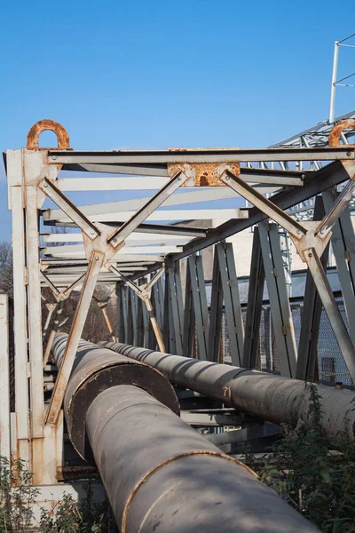 Demiryolu yakınında boruları olan paslı metal bir yapı.