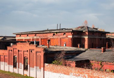 Mavi gökyüzüne karşı büyük bir kırmızı tuğla fabrikası.