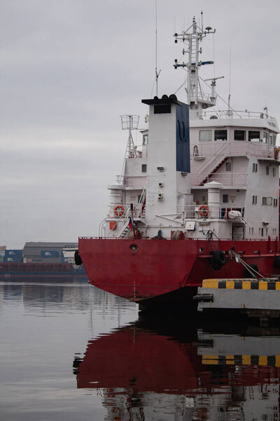 Ранним утром у берега на набережной Калининграда стоит белый корабль с красной палубой