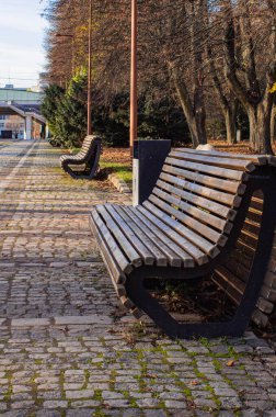 Parktaki sokakta tahta bir bank. 