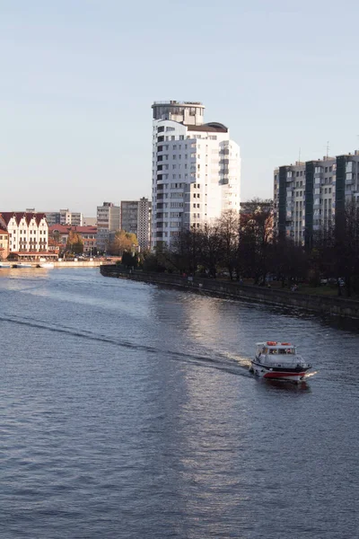 Boot op de rivier tegen de achtergrond van moderne gebouwen overdag — Stockfoto