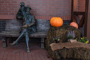 Bir erkek heykeli, balkabakları ve çiçekler sokak tasarımında samanlıkta