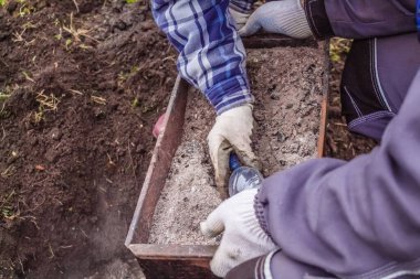 Kadın ve erkek bitkileri ekmek için toprağı külle gübrelerler.