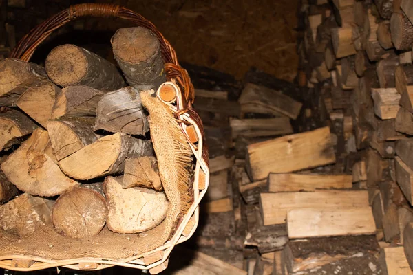 Schöner Weidenkorb mit Brennholz im Vordergrund — Stockfoto