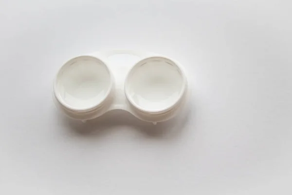 An open white container for lenses on the white background — Stock Photo, Image