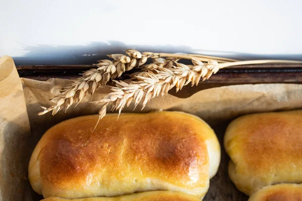 Rami di grano sullo sfondo di focacce al forno — Foto Stock