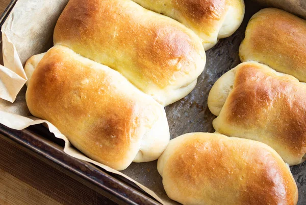 Lush, ruddy, buns in a baking tray on parchment paper close-up — Stock Photo, Image