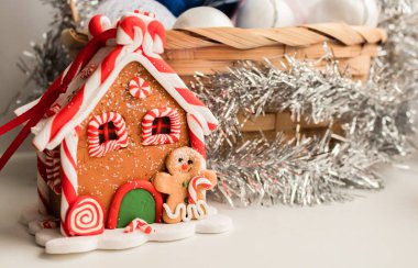 Arkaplanda çelenkli bir sepet olan zencefilli kurabiye evi.