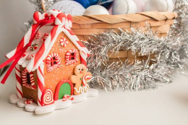 Arkaplanda çelenkli bir sepet olan zencefilli kurabiye evi.