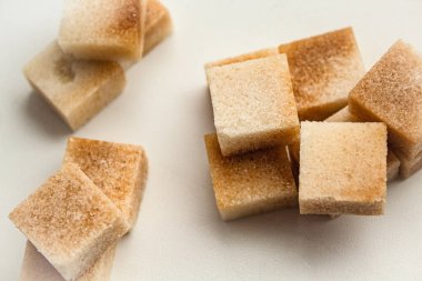 Küp şeklinde Reed şekeri bir avuç dolusu beyaz arka planda yatar.