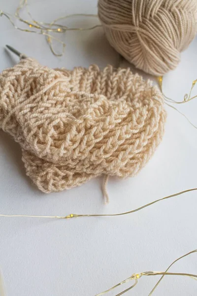 Une boule de fil de laine avec des aiguilles à tricoter et un motif de tricot anglais se trouvent sur un fond blanc près de la fenêtre — Photo