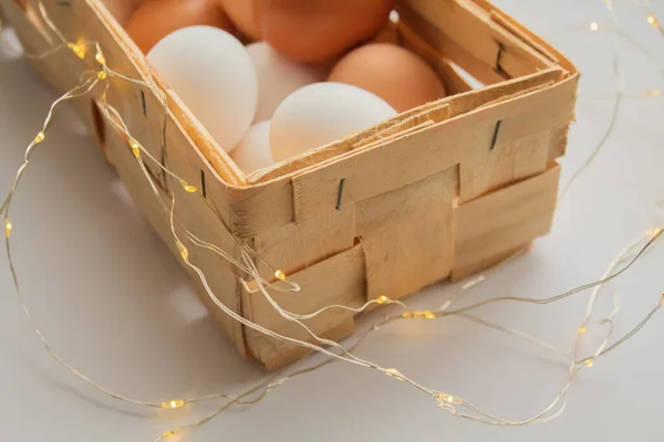 鶏の卵は白い背景にウィッカーバスケットに折り畳まれています — ストック写真