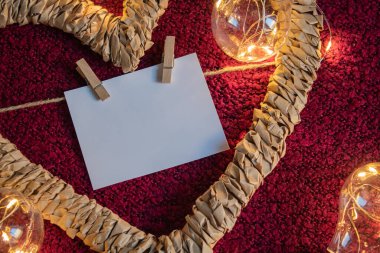 Kalp şeklinde bir çerçeve. Mandalların üzerinde bir kart. Ampullerin etrafındaki kırmızı arka planda yazılacak bir yer var.