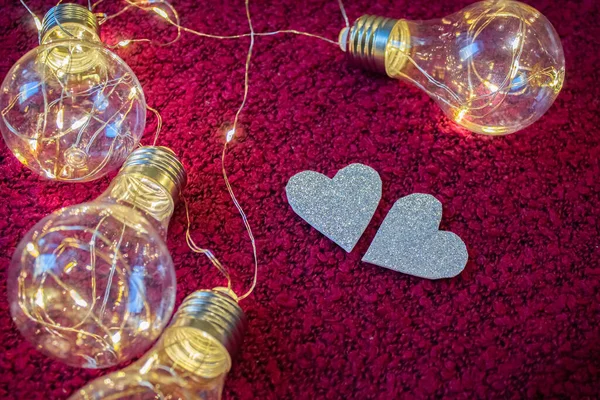 Silver Hearts Crimson Background Lies Garland Light Bulbs — Stock Photo, Image
