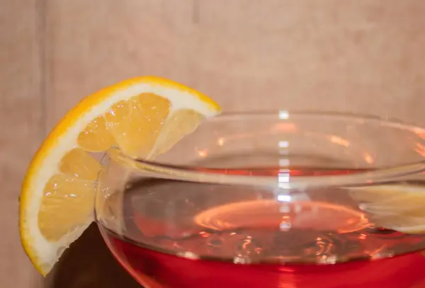 stock image Beautiful glass with pink wine with a piece of lemon 