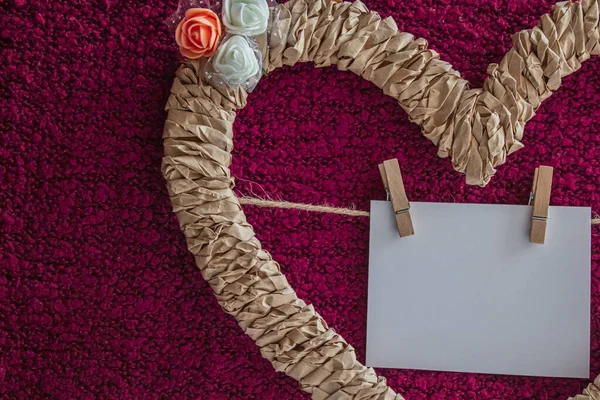 Плетеное сердце, украшенное цветами с карточкой на нитке — стоковое фото