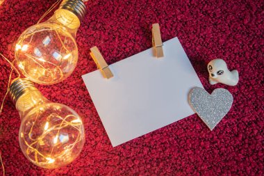 Üstünde mandallar ve gümüş bir kalp bulunan kart, bir çelenk gibidir. 