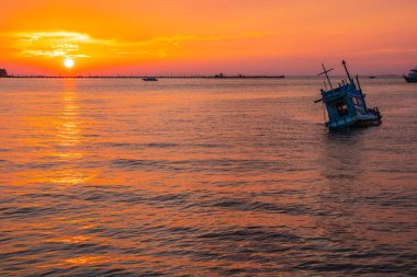 Tayland Körfezi 'nde gün batımında eski bir gemi.