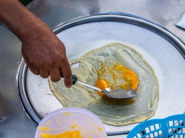 Tayland 'da seyyar bir cadde yiyecek dükkanında muzlu krep hazırlıyorum.