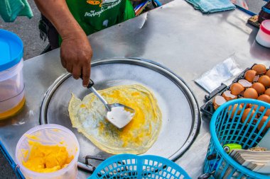 Tayland 'da seyyar bir cadde yiyecek dükkanında muzlu krep hazırlıyorum.
