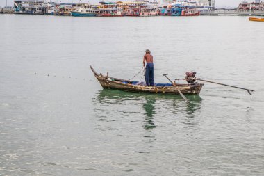 Deniz kenarında çalışan bir balıkçı.