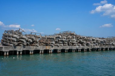 Paslı, terk edilmiş bir limandaki kaya midyesi kaplı metal borular sanayinin deniz ekosistemleri üzerindeki çevresel etkisini simgeliyor..