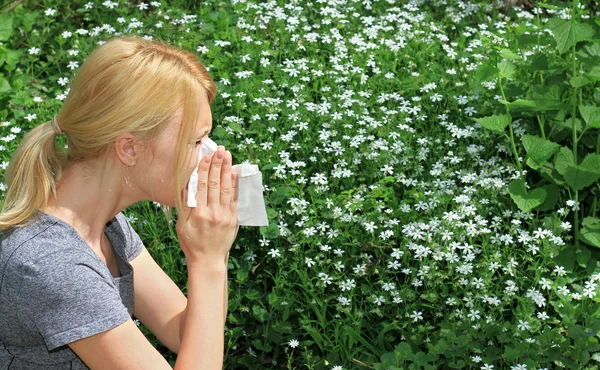 Allergia al polline, primavera. Donna starnutisce in un tessuto — Foto Stock