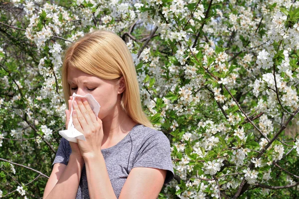 Alergia al polen, primavera. Mujer estornudando en un pañuelo — Foto de Stock