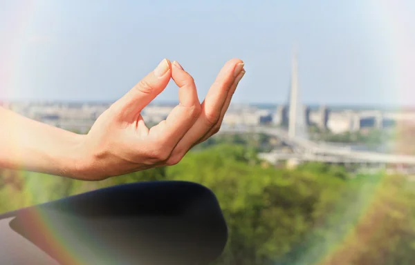 Femme méditant en position de yoga dans la nature / parc avec vue sur la ville de près . — Photo