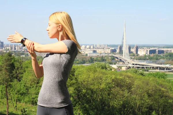 Vrouw die zich uitstrekt voordat training buitenshuis. Sport, fitness, actieve levensstijl concept — Stockfoto